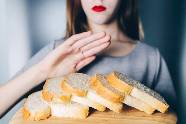 Gluten intolerance and diet concept. Young girl refuses to eat white bread Gluten intolerance and diet concept. Young girl refuses to eat white bread dough stock pictures, royalty-free photos & images