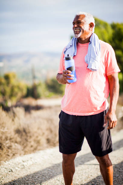 uomo nero anziano che si allea - drinking men water bottle foto e immagini stock