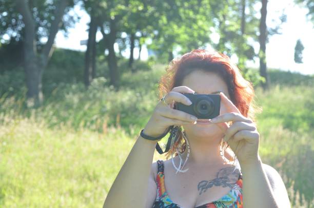 istock woman taking picture  in a park 927983184