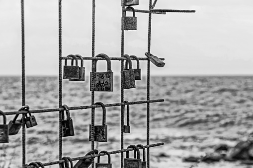Naples, Italy - February 02, 2018: Lovelocks on fence with ocean in Naples Italy.