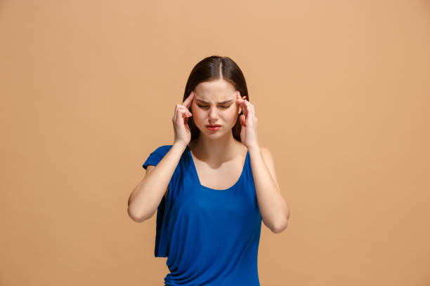 istock Woman having headache. Isolated over pastel background 927994568