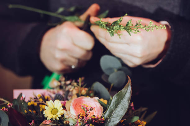 istock Modern florist working with flowers in workshop - with detail on hands 927995402