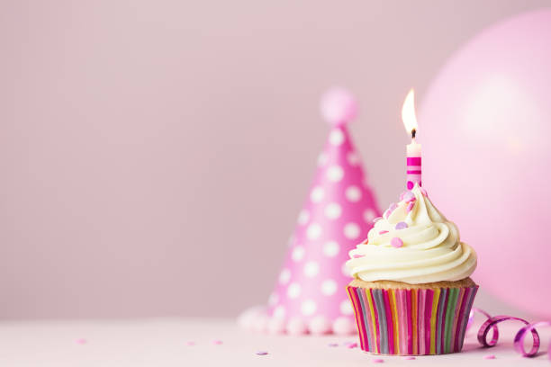 magdalena con glaseado con velas cumpleaños - pink hat fotografías e imágenes de stock
