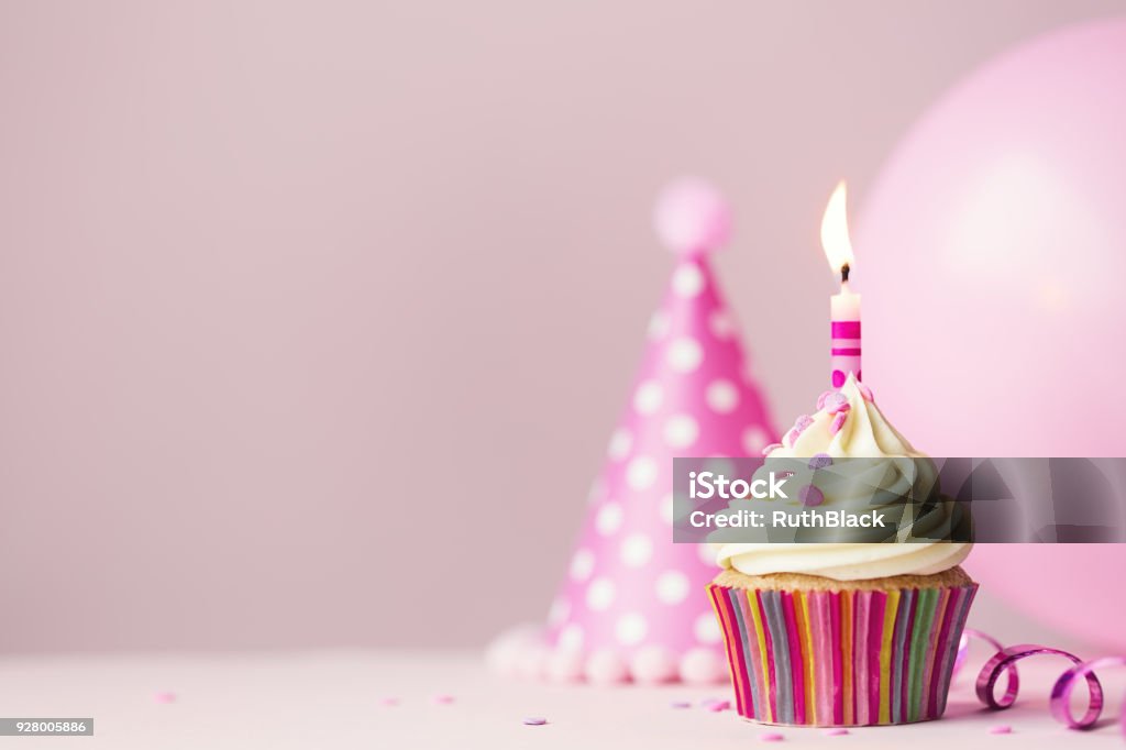 Birthday cupcake with candle Birthday cake with single candle and party balloon Birthday Stock Photo