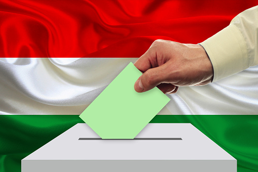 Man voting on elections in Hungary front of flag