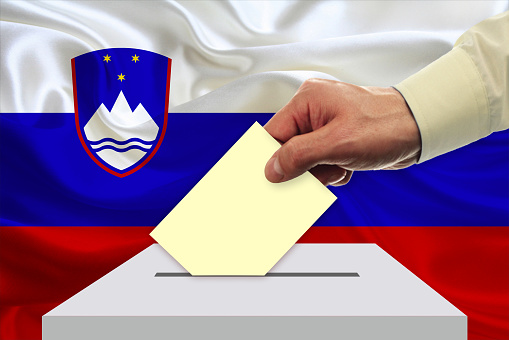 Man voting on elections in slovenia front of flag