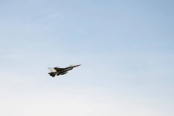 istock f16 falcon fighter jet flying on blue sky background 928009140