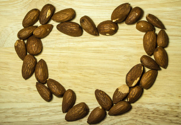 istock Almonds are arranged heart frame on a wooden table 928009704