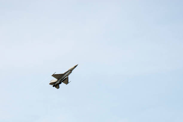 istock f16 falcon fighter jet flying on blue sky background 928013350