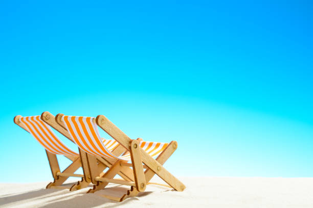 istock Two sun loungers on the sandy beach and the sky with copy space 928014690