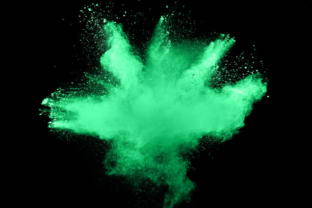 istock green color powder explosion cloud isolated on black background. Green dust splashing on dark background. 928016570