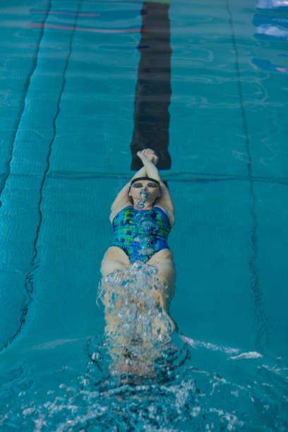 istock Female swimmer gushing through water in pool 928017204