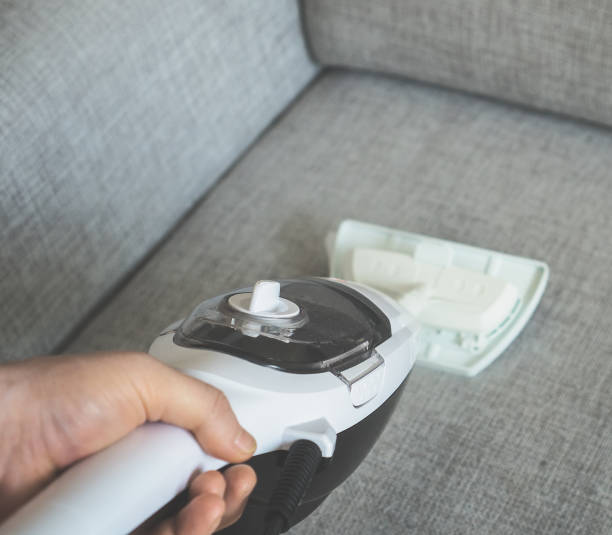 istock Cleaning fabric of the sofa with a steam cleaner. 928017428
