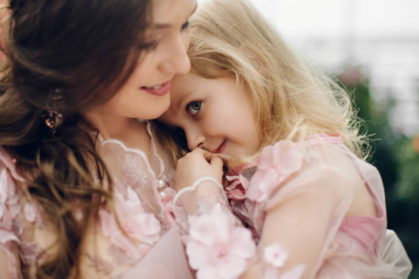 istock little daughter cuddles up to her mom and smiles 928020708