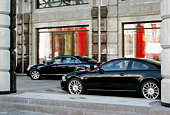 Two black cars in front of a building