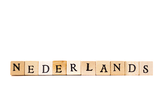 Wood Block Letters Spelling “NEDERLANDS”; White background with plenty of copy space.
