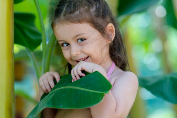 istock Cute little girl posing with palm trees 928034492
