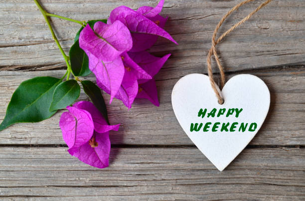 istock Happy Weekend concept.Bougainvillea flowers and decorative white heart with text on rustic background. 928034522