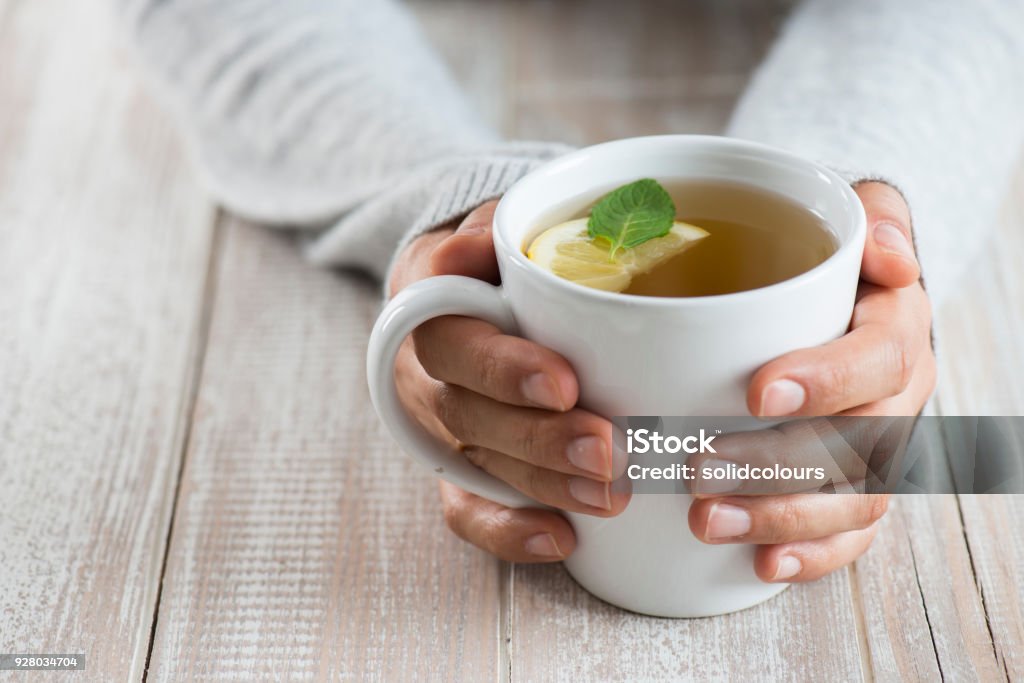 Woman with herbal tea Herbal tea on wood background. Woman holding mug. Tea - Hot Drink Stock Photo