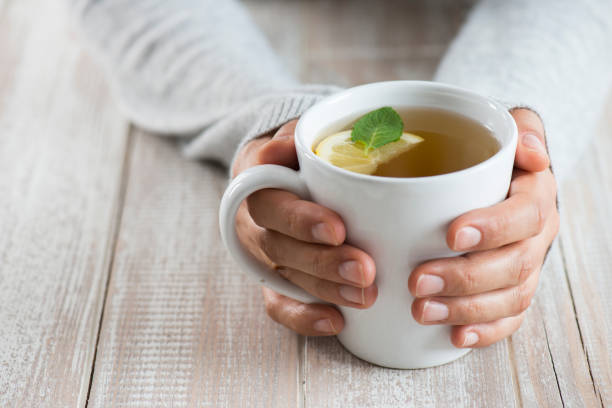 Woman with herbal tea Herbal tea on wood background. Woman holding mug. cup of tea hands stock pictures, royalty-free photos & images