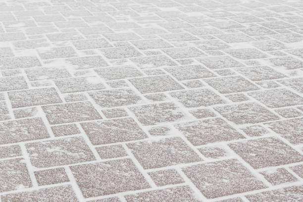Pavement of red tiles under the frost and snow. Ice in the city, cold weather. stock photo
