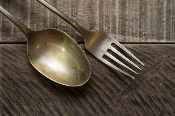 istock old brass spoon and fork on wooden board 928035484