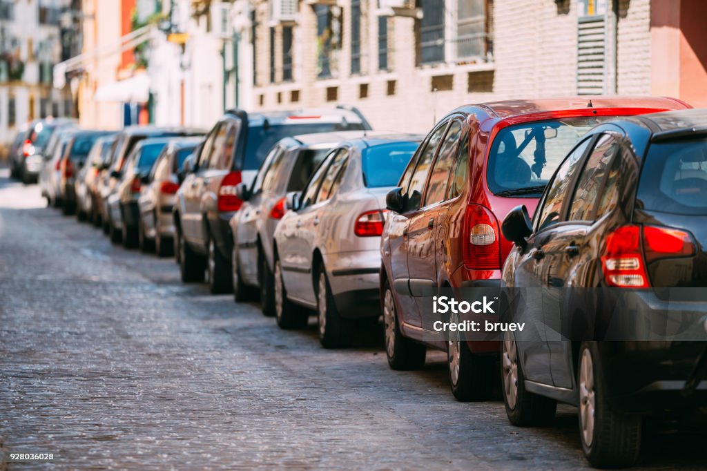 Coches aparcados en la calle en la ciudad europea en día soleado de verano - Foto de stock de Aparcar libre de derechos