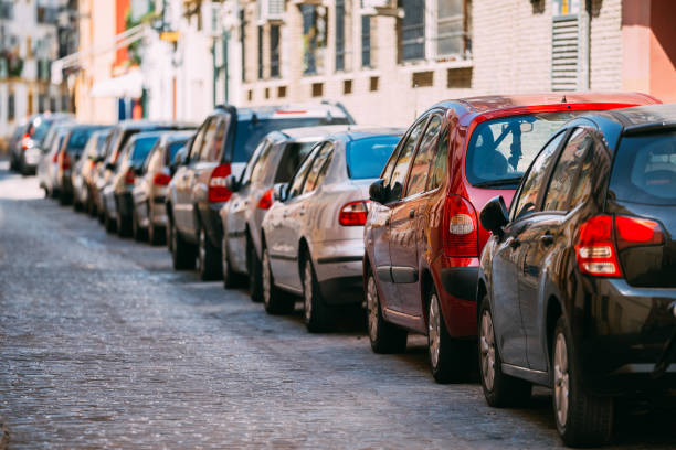 voitures garées dans la rue dans la ville européenne dans la journée d’été ensoleillée - gare photos et images de collection