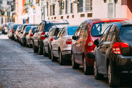 Cars Parked On Street In European City In Sunny Summer Day.