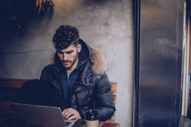 istock Man sitting in coffee shop and using laptop computer 928036430