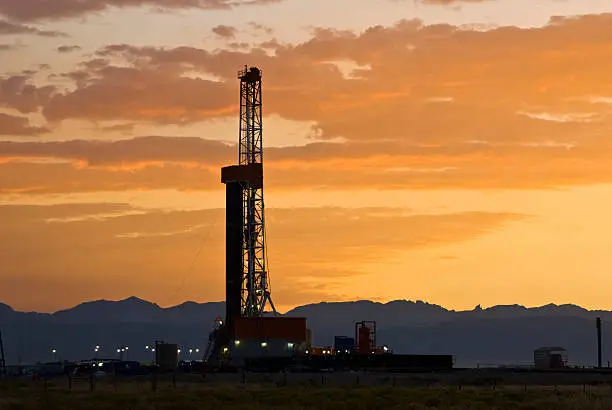 Photo of Oil drilling rig with a sunset in the background