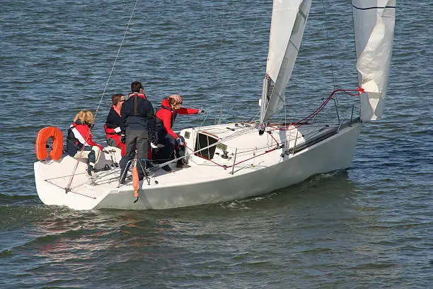 Sailing teacher with three students on a sailingboat at sea