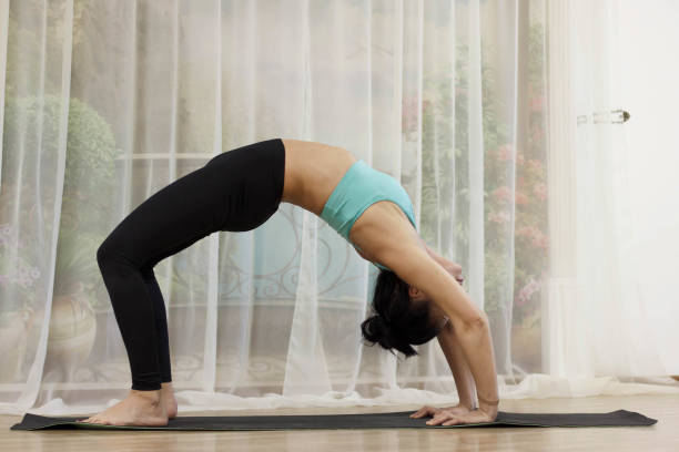 istock A middle-aged woman does yoga. Chakrasana(Wheel Pose) 928040372