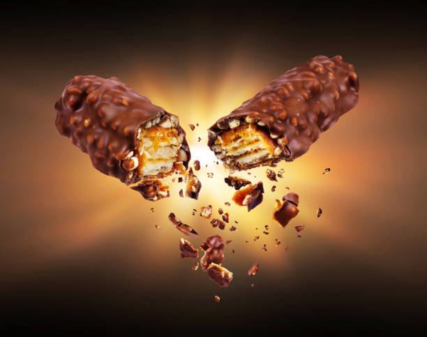 istock Waffle chocolate bar with nuts broken into two parts in the dark 928046940