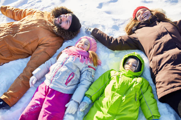 istock Happy family lying in snow 928047332