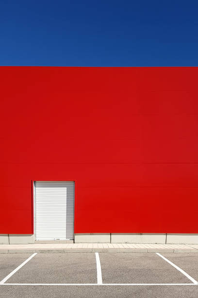 istock Empty parking lot with a red wall and blue sky 928047622