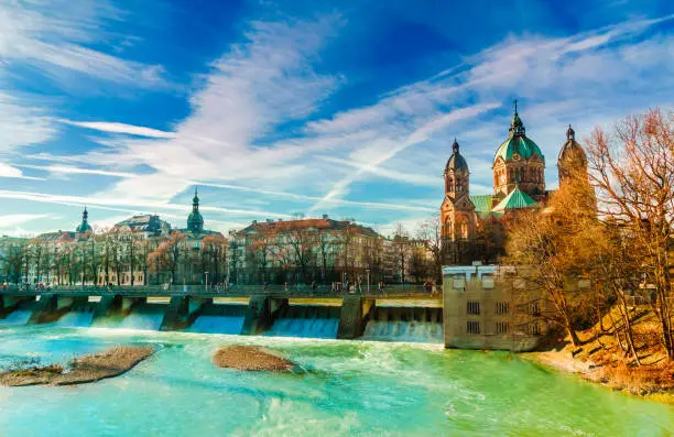 View on winter landscape by turquoise Isar and St. Anna church in Munich