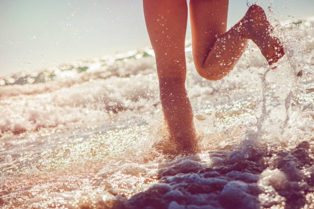 istock Girl running in the sea 928058252