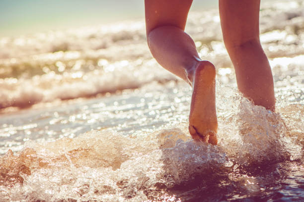 istock Girl running in the sea 928058280