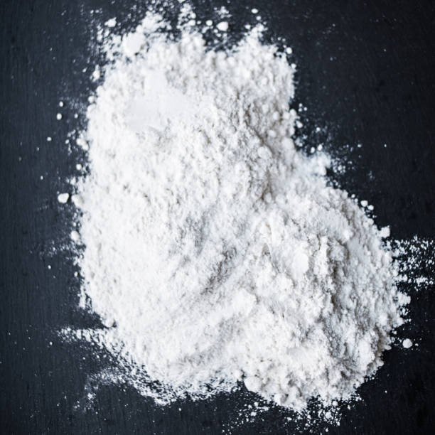 istock White Flour powder on black background, dust splash clouds. Baking preparation, top view. Cooking recipe concept