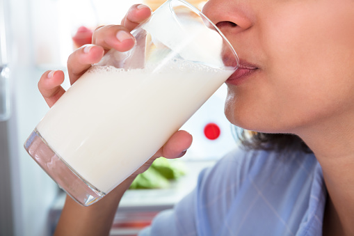 Close-up Of A Woman Drinking Glass Of Fresh Milk