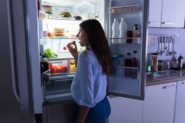 istock Woman Eating Cookie In Kitchen 928066190