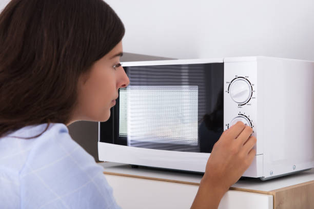 istock Woman Preparing Food In Microwave Oven 928066228