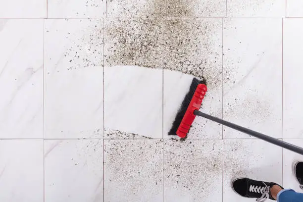 Photo of Broom Cleaning Dirt On Tiled Floor