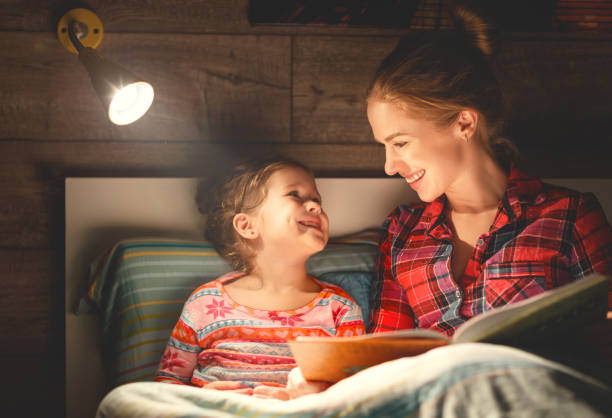 istock mother and child reading book in bed before going to sleep 928069368