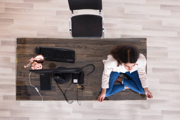 istock Female Worker Meditating On Top Of The Desk 928069694