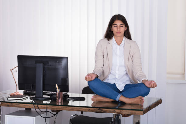 istock Female Worker Meditating On Top Of The Desk 928069708