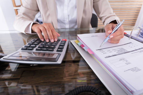 istock Businesswoman Hand Calculating Invoice Using Calculator 928069724