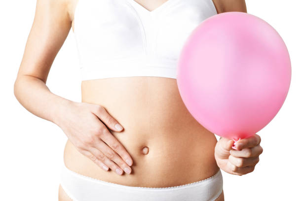 närbild av kvinna som bär underkläder håller rosa ballong och trycka på magen - kvinna ballonger bildbanksfoton och bilder