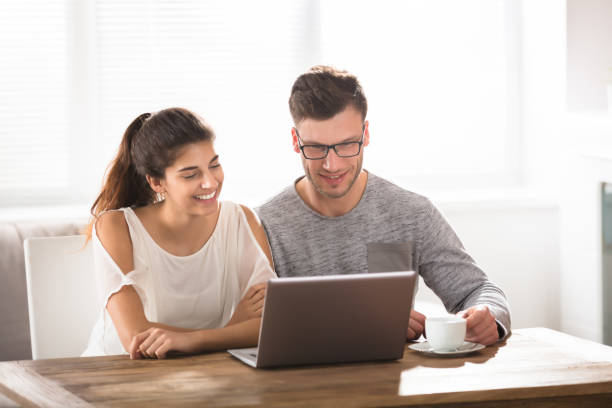 istock Happy Couple Looking At Laptop On Table 928073710